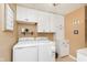 Well organized laundry area featuring a washer, dryer, and ample white cabinet storage space at 3723 S Dearborn St, Indianapolis, IN 46237