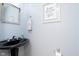 Stylish powder room with a unique black pedestal sink and decorative mirror at 3723 S Dearborn St, Indianapolis, IN 46237