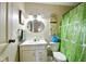The bathroom has wallpaper, a vanity, an oval mirror, and a toilet with green accents at 4505 Stratford Dr, Anderson, IN 46013
