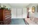 This bedroom features three closets, a dark wood dresser, and a striped chaise lounge at 4505 Stratford Dr, Anderson, IN 46013