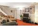 Comfortable living room featuring a sofa, television, stairs, and neutral decor at 4505 Stratford Dr, Anderson, IN 46013