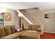 Comfortable living room featuring a sofa, stairs, and neutral decor at 4505 Stratford Dr, Anderson, IN 46013