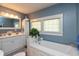 Relaxing bathroom with a soaking tub, blue walls, and ample natural light at 455 E Main St, Danville, IN 46122