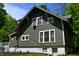 Side view of a charming home featuring detailed windows, a full basement, and manicured landscaping at 455 E Main St, Danville, IN 46122