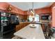 An eat-in kitchen features wood cabinets, black appliances, and ample counter space with a statement light fixture at 455 E Main St, Danville, IN 46122