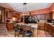 Eat-in kitchen featuring wood cabinets, island with seating, black appliances and access to the stairs at 455 E Main St, Danville, IN 46122