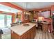 View of the kitchen with a center island, wooden cabinets, access to the deck, and breakfast nook at 455 E Main St, Danville, IN 46122