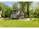 Outbuilding with an adjacent patio featuring a fire pit, surrounded by mature trees for a secluded feel at 455 E Main St, Danville, IN 46122