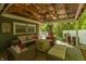 Relaxing covered patio with comfortable seating, a ceiling fan, and a wooded view at 455 E Main St, Danville, IN 46122