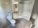 Bathroom renovation featuring new toilet, walk-in shower, fresh paint, and gray flooring at 4986 Adkins St, Columbus, IN 47201