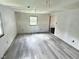 Spacious bedroom featuring new gray flooring, fresh paint, and a bright window at 4986 Adkins St, Columbus, IN 47201
