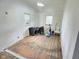 Living room showcasing hardwood floors, windows, and newly plastered walls, creating an inviting space at 4986 Adkins St, Columbus, IN 47201