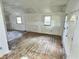 Bright living room featuring hardwood floors, windows, and a door leading to the backyard, ready for updates at 4986 Adkins St, Columbus, IN 47201