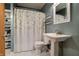Bathroom featuring a toilet, pedestal sink, and shower with storage shelves at 506 S Green St, Brownsburg, IN 46112