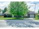 Charming home boasts mature trees, neutral siding, a front porch, and a convenient attached garage at 506 S Green St, Brownsburg, IN 46112