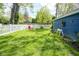 Large backyard with lush green grass, a white picket fence, and colorful outdoor furniture at 5119 Ralston Ave, Indianapolis, IN 46205