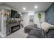 Finished basement with a gray sectional sofa, modern fireplace, and decorative wall paneling at 5119 Ralston Ave, Indianapolis, IN 46205