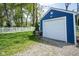 Detached garage with a white door, adjacent to a well-maintained yard and picket fence at 5119 Ralston Ave, Indianapolis, IN 46205