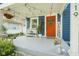 Inviting front porch decorated with string lights, a bench, and a bright orange door with seasonal decorations at 5119 Ralston Ave, Indianapolis, IN 46205