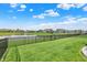 Spacious backyard features a well-maintained lawn, black fence, and peaceful pond with community views at 5248 Holborn Ave, McCordsville, IN 46055