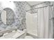 Well-lit bathroom with decorative wallpaper, a single sink vanity, and a shower-tub combo with curtain at 5248 Holborn Ave, McCordsville, IN 46055
