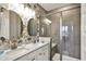 Bathroom with updated double vanity, designer mirrors, tiled shower, and wallpaper at 5248 Holborn Ave, McCordsville, IN 46055