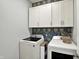 Laundry room with updated washer and dryer, stylish wallpaper, and upper storage cabinets at 5248 Holborn Ave, McCordsville, IN 46055