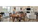 Bright living room featuring a round wood table, fireplace, and access to a covered patio with lake view at 5248 Holborn Ave, McCordsville, IN 46055