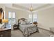 Bright main bedroom with trey ceiling, chandelier, and large window with plantation shutters at 5248 Holborn Ave, McCordsville, IN 46055