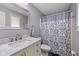 Bathroom with white vanity, marble countertop, a decorative mirror, and patterned shower curtain at 5312 Larita Ln, Anderson, IN 46017