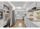 Open-concept kitchen with stainless steel appliances, white cabinets, and laminate wood flooring at 5312 Larita Ln, Anderson, IN 46017