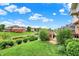 Backyard featuring a well-maintained lawn, landscaping, and serene pond view with neighborhood homes at 5377 Crooked Stick Ct, Greenwood, IN 46142