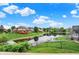 Backyard view of a serene pond surrounded by lush greenery, with a well-manicured lawn and neighborhood scenery at 5377 Crooked Stick Ct, Greenwood, IN 46142