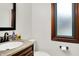 Stylish half-bath features a granite countertop, black fixtures, and a window for natural light at 5377 Crooked Stick Ct, Greenwood, IN 46142