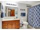 Well-lit bathroom with a wooden vanity, patterned shower curtain, and blue accents for a fresh, clean feel at 5377 Crooked Stick Ct, Greenwood, IN 46142