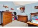 Spacious bedroom featuring wooden dressers, sports-themed decor, and a comfortable bed, perfect for relaxation and leisure at 5377 Crooked Stick Ct, Greenwood, IN 46142