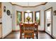 Charming dining room with wood table, six chairs, bay windows and an outdoor view at 5377 Crooked Stick Ct, Greenwood, IN 46142