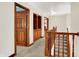 Upstairs hallway with wood trim and banister, built-in wooden cabinet, and neutral carpet at 5377 Crooked Stick Ct, Greenwood, IN 46142