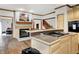 Kitchen island with cooktop and granite countertops, plus a fireplace and hardwood floors at 5377 Crooked Stick Ct, Greenwood, IN 46142