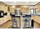 Well-lit kitchen with light wood cabinets, stainless steel fridge, and island with seating at 5377 Crooked Stick Ct, Greenwood, IN 46142