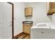 Functional laundry room with a sink, storage cabinets, and a modern washing machine at 5377 Crooked Stick Ct, Greenwood, IN 46142