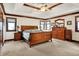 A luxurious main bedroom featuring wood trim, a tray ceiling, a ceiling fan and a matching furniture set at 5377 Crooked Stick Ct, Greenwood, IN 46142