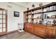 Spacious office area features wooden built-ins, laminate flooring, and a door to a backyard at 5377 Crooked Stick Ct, Greenwood, IN 46142