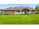 Expansive backyard showcasing the brick home, lush green lawn, and charming white porch, perfect for outdoor enjoyment at 5601 W Sun Point Dr, Muncie, IN 47304