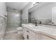 Updated bathroom showcasing modern vanity, framed mirror, sleek black hardware, and glass-enclosed shower at 5601 W Sun Point Dr, Muncie, IN 47304