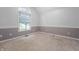 Cozy bedroom with large window, neutral walls and carpet, featuring a chair rail at 5601 W Sun Point Dr, Muncie, IN 47304