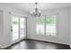 Cozy dining area with chandelier lighting, sliding glass doors to the deck, and bright windows at 5601 W Sun Point Dr, Muncie, IN 47304