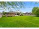 Wide shot of an expansive backyard with lush lawn behind a brick home on a sunny day at 5601 W Sun Point Dr, Muncie, IN 47304