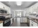 Open concept kitchen featuring modern appliances, granite countertops, and views into the dining and living areas at 5601 W Sun Point Dr, Muncie, IN 47304