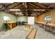 Spacious garage featuring wood beams, multiple tables, and natural light at 5855 S 25 W, Lebanon, IN 46052